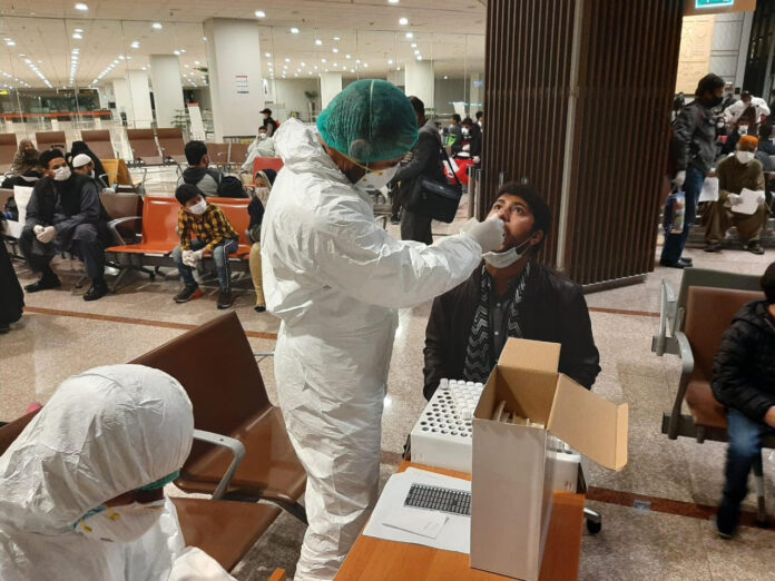 Pakistani-health-officials-prforming-coronavirus-tests-at-Islamabad-Airport.jpg