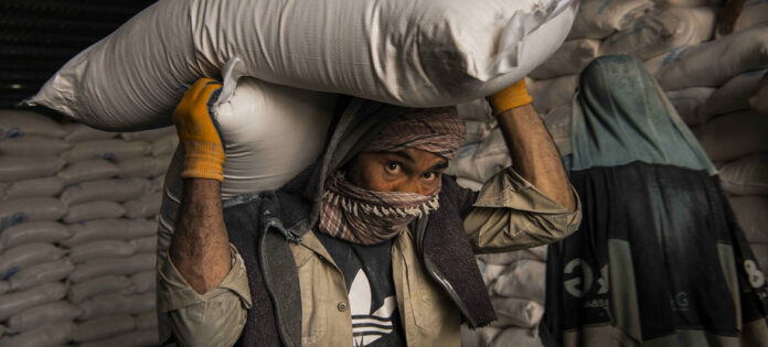 A-man-carrying-a-sack-of-grains-from-WFP-office-in-Kabul-May-2021-WFP-image.jpg